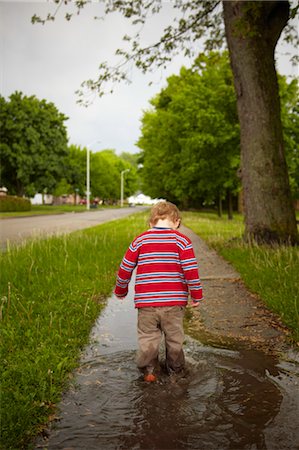 Boy Walking through Puddles, Stratford, Ontario Foto de stock - Con derechos protegidos, Código: 700-03502762