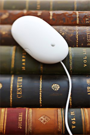 Gros plan d'une souris d'ordinateur sur cuir lié livres Photographie de stock - Rights-Managed, Code: 700-03553414