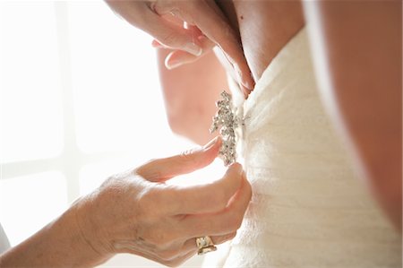 Afixing broche à l'arrière de la robe de mariée Photographie de stock - Rights-Managed, Code: 700-03587090