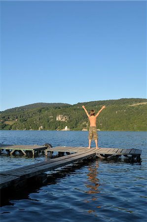 summer cottage casual - Little Boy Standing on Dock With Arms in the Air Stock Photo - Rights-Managed, Code: 700-03622825