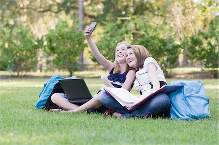 Deux jeunes filles à faire leurs devoirs sur l'herbe Photographie de stock - Rights-Managed, Code: 700-03644524