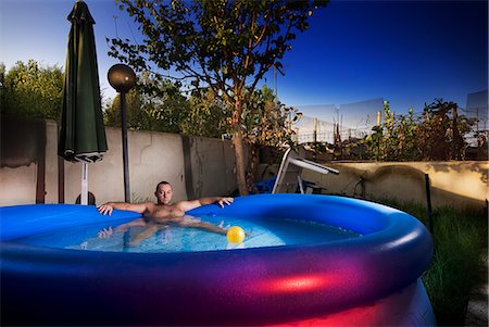 Man Relaxing in Inflatable Swimming Pool Stock Photo - Rights-Managed, Code: 700-03665638