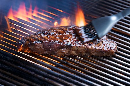 flaming cook - Brush Basting Steak with Barbeque Sauce Foto de stock - Con derechos protegidos, Código: 700-03665671