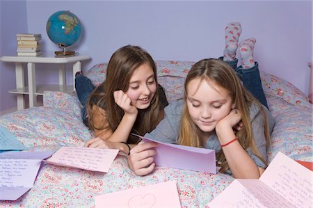 Deux filles lisant les lettres d'amour sur le lit Photographie de stock - Rights-Managed, Code: 700-03662323