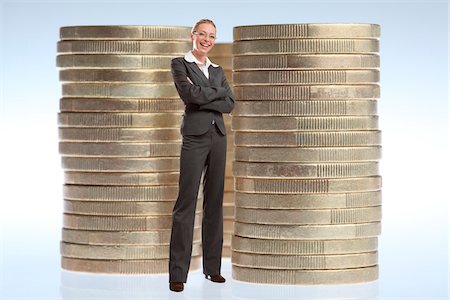 scale contrast in size - Businesswoman Standing in front of Stacks of Large Coins Stock Photo - Rights-Managed, Code: 700-03685808