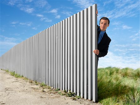 spying person - Businessman Peeking Out from Behind Eternal Fence Stock Photo - Rights-Managed, Code: 700-03698119