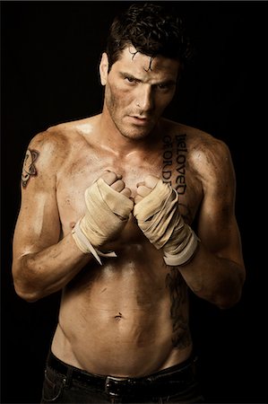 Homme sale avec les poings enveloppé dans des bandages de boxe main Photographie de stock - Rights-Managed, Code: 700-03692140