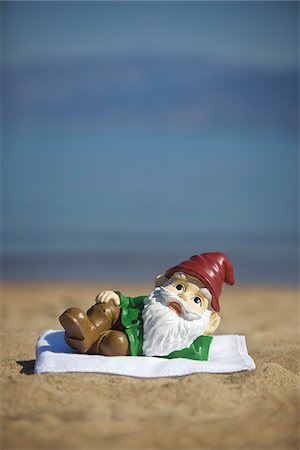 Garden Gnome Lying on Towel on Beach Stock Photo - Rights-Managed, Code: 700-03739356
