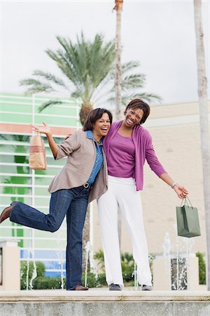 Two Women with Shopping Bags Standing on Edge of Fountain Foto de stock - Con derechos protegidos, Código: 700-03762658