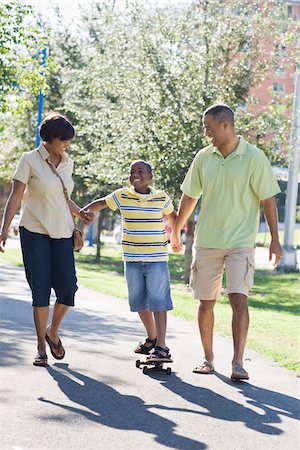 family walking in park holding hands - Parents Helping Child Skateboard Stock Photo - Rights-Managed, Code: 700-03762712