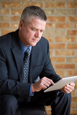 executive suited man sitting - Businessman Using iPad Stock Photo - Rights-Managed, Code: 700-03777999