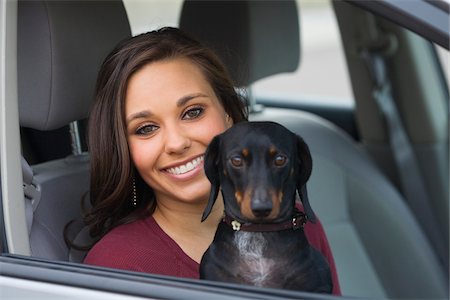 Lächelnde Frau sitzen im Auto, einen Hund auf dem Schoß hält Stockbilder - Lizenzpflichtiges, Bildnummer: 700-03778518