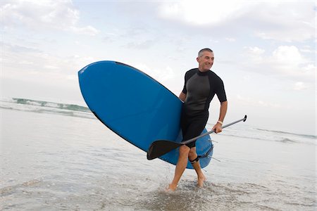 simsearch:700-03777182,k - Paddle Boarder walking on the beach Foto de stock - Con derechos protegidos, Código: 700-03787180