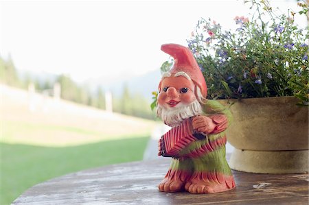 fisarmonica - Garden Gnome on Table with Pot of Flowers Fotografie stock - Rights-Managed, Codice: 700-03783338