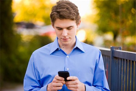 Young Businessman Using Cell Phone Foto de stock - Con derechos protegidos, Código: 700-03799537
