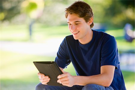 Man Using iPad in Park Foto de stock - Con derechos protegidos, Código: 700-03799532