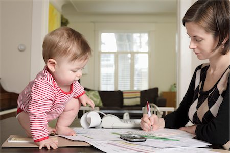 simsearch:6108-05867323,k - Woman Doing Paperwork with Baby on Table Stock Photo - Rights-Managed, Code: 700-03799541