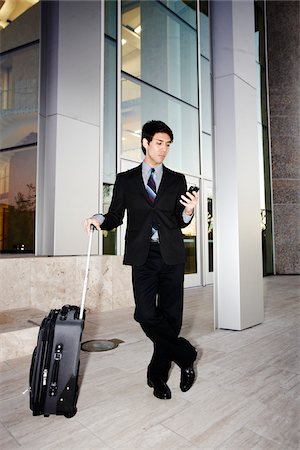 executive and standing and outdoors male - Businessman with Cell Phone and Suitcase Foto de stock - Con derechos protegidos, Código: 700-03814350