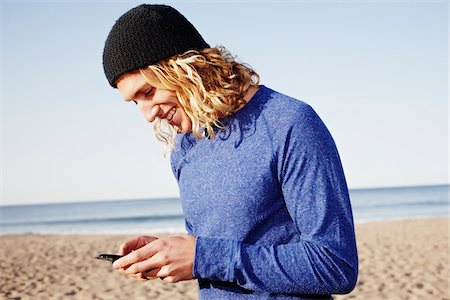 Homme à l'aide de téléphone portable sur la plage Photographie de stock - Rights-Managed, Code: 700-03814403