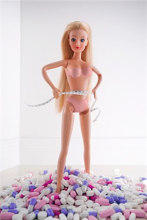 schmal - Blond Doll halten Maßband stehen inmitten von Diät-Pillen Stockbilder - Lizenzpflichtiges, Bildnummer: 700-03815221