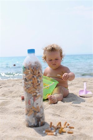 dislikes - Girl Playing with Cigarette Butts on Beach Stock Photo - Rights-Managed, Code: 700-03836233