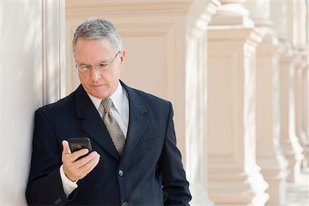 executive suits for senior men - Businessman Checking Cell Phone Stock Photo - Rights-Managed, Code: 700-03848838