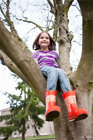 smile girl with footwear - Girl Wearing Rainboots Sitting in Tree Stock Photo - Rights-Managed, Code: 700-03849381