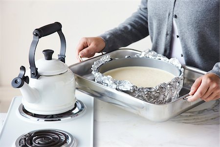 simsearch:6115-08066623,k - Frau Holding Pan mit Käsekuchen Batter neben Wasserkocher Stockbilder - Lizenzpflichtiges, Bildnummer: 700-03849765