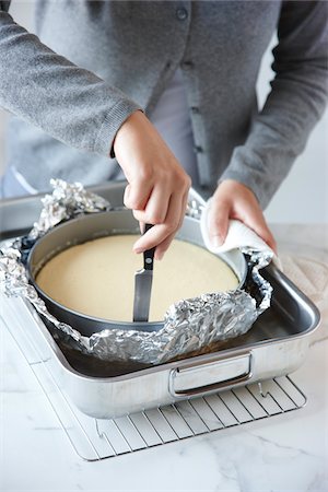 Woman Cutting Edge of Cheesecake with Knife Stock Photo - Rights-Managed, Code: 700-03849763