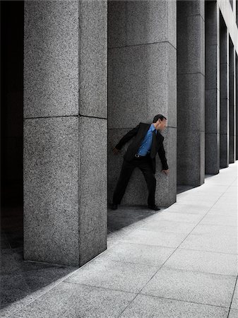 petrified - Businessman Peeking Around Column Foto de stock - Con derechos protegidos, Código: 700-03891182