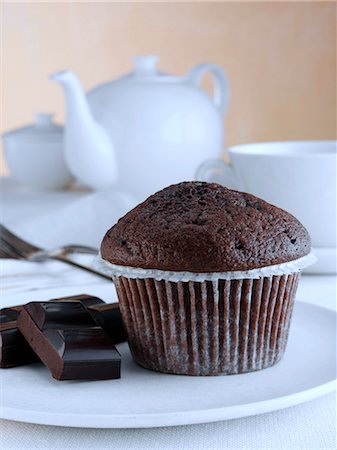 Breakfast chocolate muffin with chocolate pieces and tea set Stockbilder - Lizenzpflichtiges, Bildnummer: 824-07585987