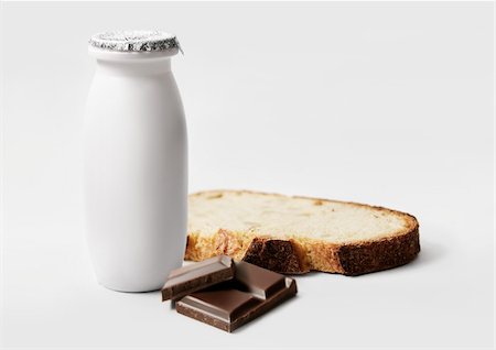 Kleine Flasche Milch, Quadrate aus Schokolade und eine Scheibe Brot Stockbilder - Lizenzpflichtiges, Bildnummer: 825-05814921