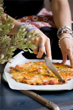 fine herb - Femme pour trancher une pizza au fromage Photographie de stock - Rights-Managed, Code: 825-05815720