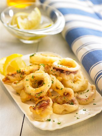 Deep-fried calamary rings with lemon and parsley Foto de stock - Con derechos protegidos, Código: 825-06048400