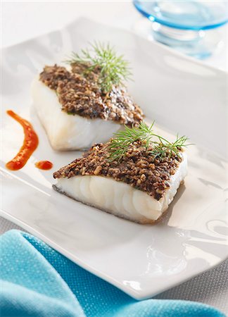 simsearch:652-03803045,k - Thick pieces of cod with black olive and pine nut crust Fotografie stock - Rights-Managed, Codice: 825-06815053