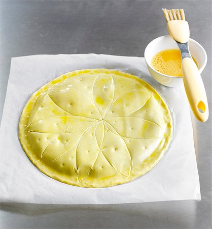 Coating the pie dough with a beaten egg yolk Fotografie stock - Rights-Managed, Codice: 825-06816420