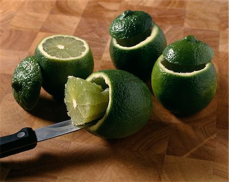 Scooping out the flesh of the limes with a knife Photographie de stock - Rights-Managed, Code: 825-07075793