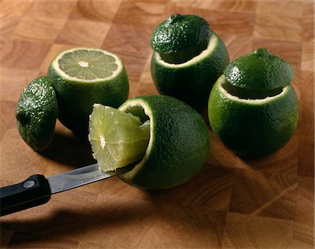 schellfisch - Scooping out the flesh of the limes with a knife Photographie de stock - Rights-Managed, Code: 825-07075793