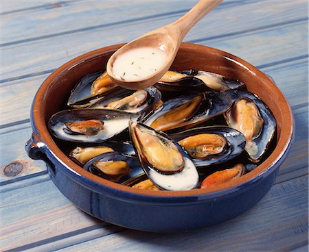 pouring - Pouring the sauce onto the mussels in the dish before baking Foto de stock - Con derechos protegidos, Código: 825-07075807