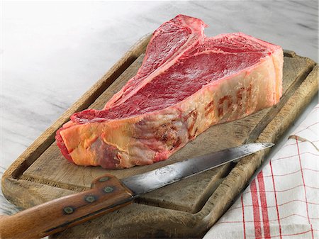steak knife - Raw T-bone steak on a chopping board Stock Photo - Rights-Managed, Code: 825-07077050