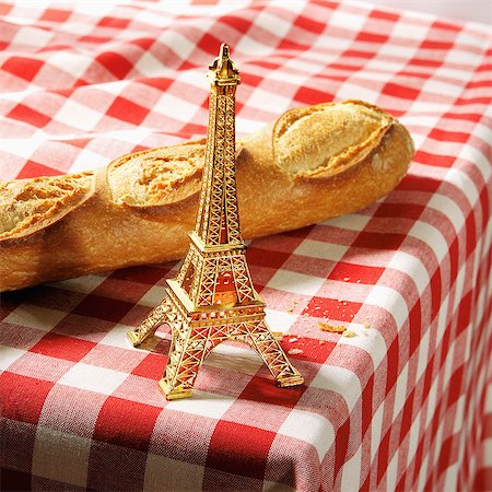 Small golden Eiffel Tower and baguette on a red and white checkered tablecloth Stockbilder - Lizenzpflichtiges, Bildnummer: 825-07077284