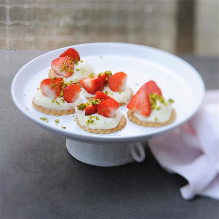 strawberry tartlet - Shortbread cookies topped with cream,strawberries and pistachios Stock Photo - Rights-Managed, Code: 825-07077458