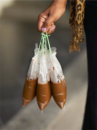 simsearch:825-07077411,k - Woman carrying plastic bags of hot coffee Stock Photo - Rights-Managed, Code: 825-07077572