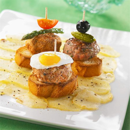 simsearch:825-07078203,k - Mini burgers on a bed on potatoes Photographie de stock - Rights-Managed, Code: 825-07078415