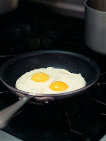 plancha de cocina - Fried eggs in a frying pan Foto de stock - Con derechos protegidos, Código: 825-02307366