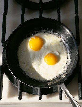 pequeno fogão portátil - Fried eggs in a frying pan Foto de stock - Direito Controlado, Número: 825-02307372