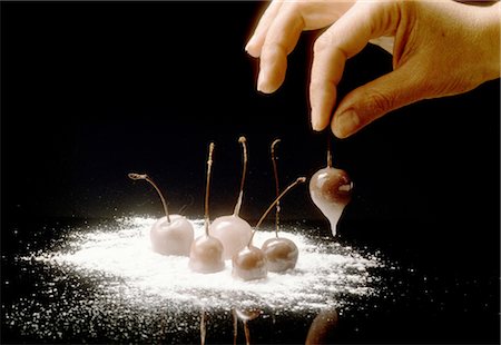 simsearch:825-05985047,k - Dipping the sugar-coated cherries in the powdered icing sugar Stock Photo - Rights-Managed, Code: 825-03629475