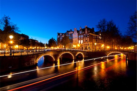 simsearch:851-02962366,k - Bridges over canals at dusk with streak of lights from boat; Amsterdam, Holland Foto de stock - Con derechos protegidos, Código: 832-08007557