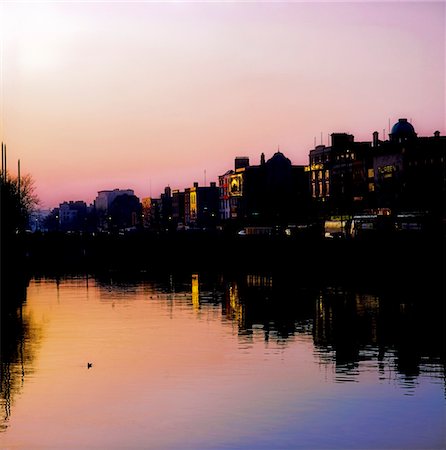 simsearch:862-03360749,k - River Liffey, Dublin, Co Dublin, Ireland; Silhouette of houses next to a river  at sunset Foto de stock - Con derechos protegidos, Código: 832-03233413