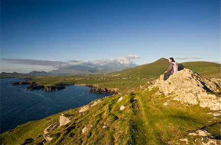 Co Kerry, Irlande ; Jeune femme admirant la vue sur une journée des étés, regardant vers la plage de Clogher et les trois sœurs Photographie de stock - Rights-Managed, Code: 832-03359286
